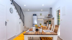 A modern kitchen with white cabinets, a microwave, and a built-in oven.