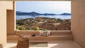 A balcony with a view of a coastal landscape, including a body of water and distant hills. - Villa Elounda - Eight Bedroom Villa, Sleeps 17 (Elounda)