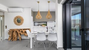 Une cuisine moderne avec des armoires blanches, un îlot central en bois et des luminaires suspendus.