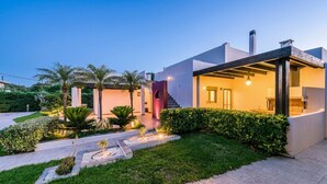 A modern house with a well-maintained garden, a covered outdoor area, and a staircase leading to the entrance. - Villa Sappho - Four Bedroom Villa, Sleeps 8 (Ialysos)