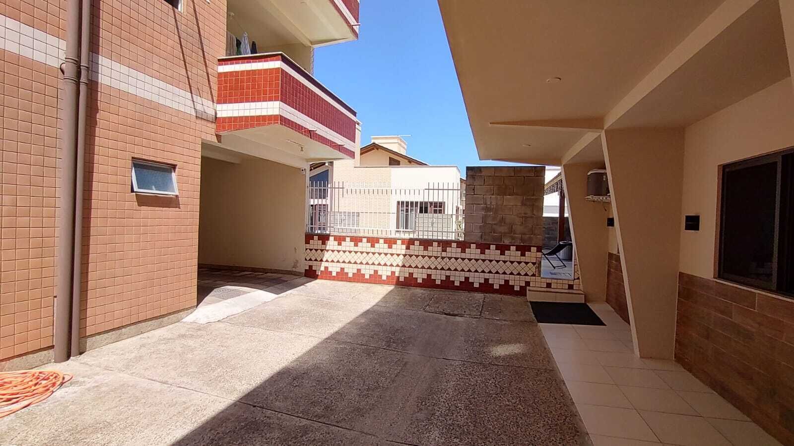A narrow corridor with tiled walls and a tiled floor, leading to a gated area with a patterned wall.