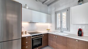 A modern kitchen with stainless steel appliances, wooden cabinets, and a built-in oven.