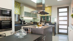 Una cocina moderna con una isla central, horno empotrado y electrodomésticos de acero inoxidable.