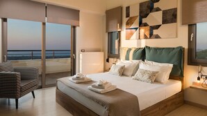 Un dormitorio moderno con una cama grande, vista al mar, un balcón y una silla a cuadros.
