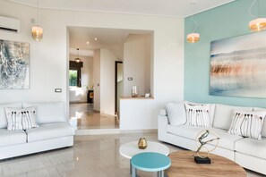 Een moderne woonkamer met twee witte banken, een salontafel en kunstwerken aan de wanden.