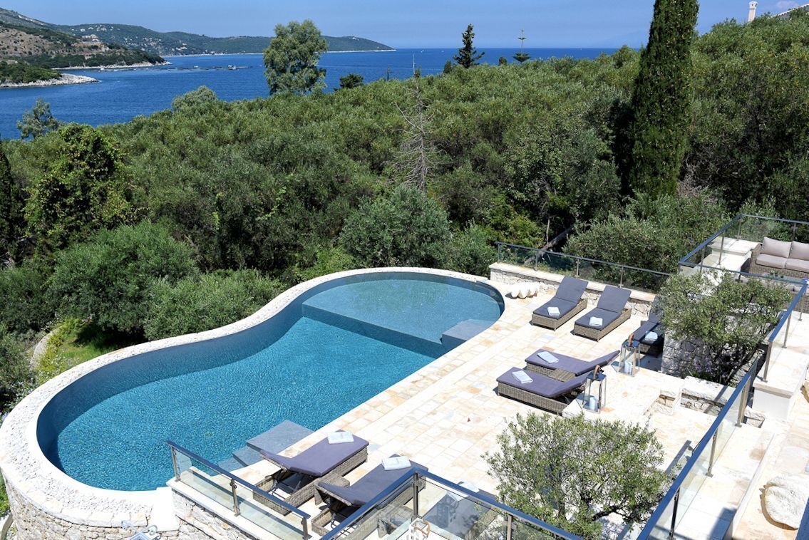 Une piscine avec des chaises longues et vue sur la mer.