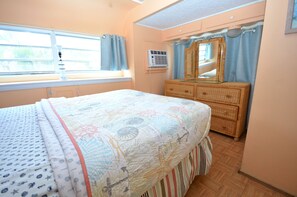 Une chambre à coucher avec un lit, une commode et une fenêtre.