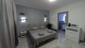 A bedroom with a bed, bedside tables, a dresser, and a nightstand.