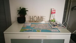 A desk with a map, a potted plant, a 'HOME' sign, and a vape pack.