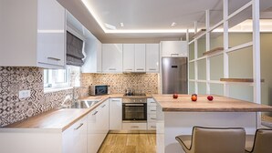 Een moderne keuken met witte kasten, een houten aanrechtblad en een ingebouwde oven.