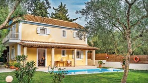 Une maison à deux étages avec une piscine, un balcon et un jardin.