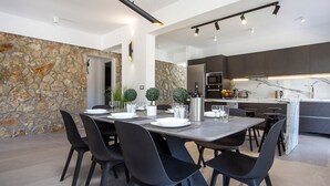 Una cocina moderna con armarios oscuros, encimera de mármol y horno empotrado.