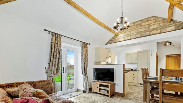 A living room with a sofa, television, and a dining area with a table and chairs. - 2 bedroom accommodation in South Barrow, near Yeovil (South Barrow, near Yeovil)