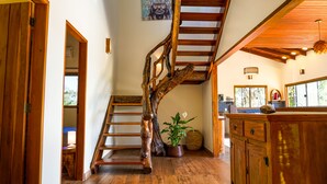 Eine Holztreppe mit natürlicher Gestaltung, ein Küchenbereich mit Holdekor und ein Fenster mit Blick ins Freie.