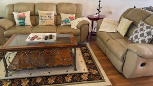Un salon avec deux canapés, une table basse, une lampe et des coussins décoratifs.