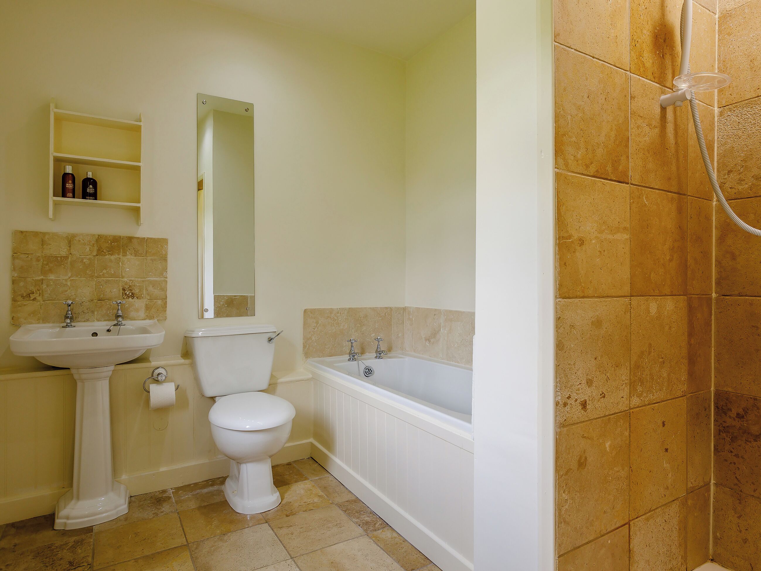 Un baño con lavabo, inodoro, espejo y bañera.