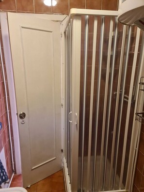 A bathroom with a shower enclosure, a toilet, and a door. - The lawyer's abode  (Campania)