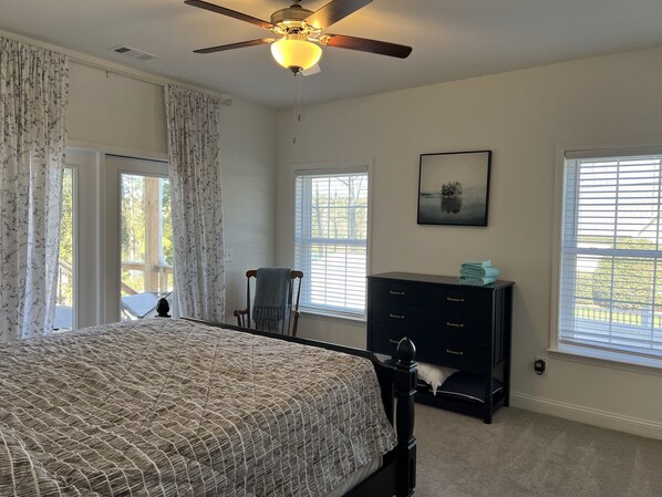 A bedroom with a bed, a dresser, a chair, and a ceiling fan. - Lake front home with a million dollar view (Starr)