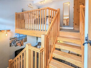 A wooden staircase with a railing, leading to a second-floor area with a view of the city. - The Hideaway Low Hawsker (Low Hawsker, near Whitby)