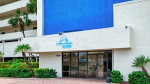 Ein Hotel mit blauem Giebel, einem Schild mit der Aufschrift 'Ocean Sands' und einer befestigten Auffahrt.