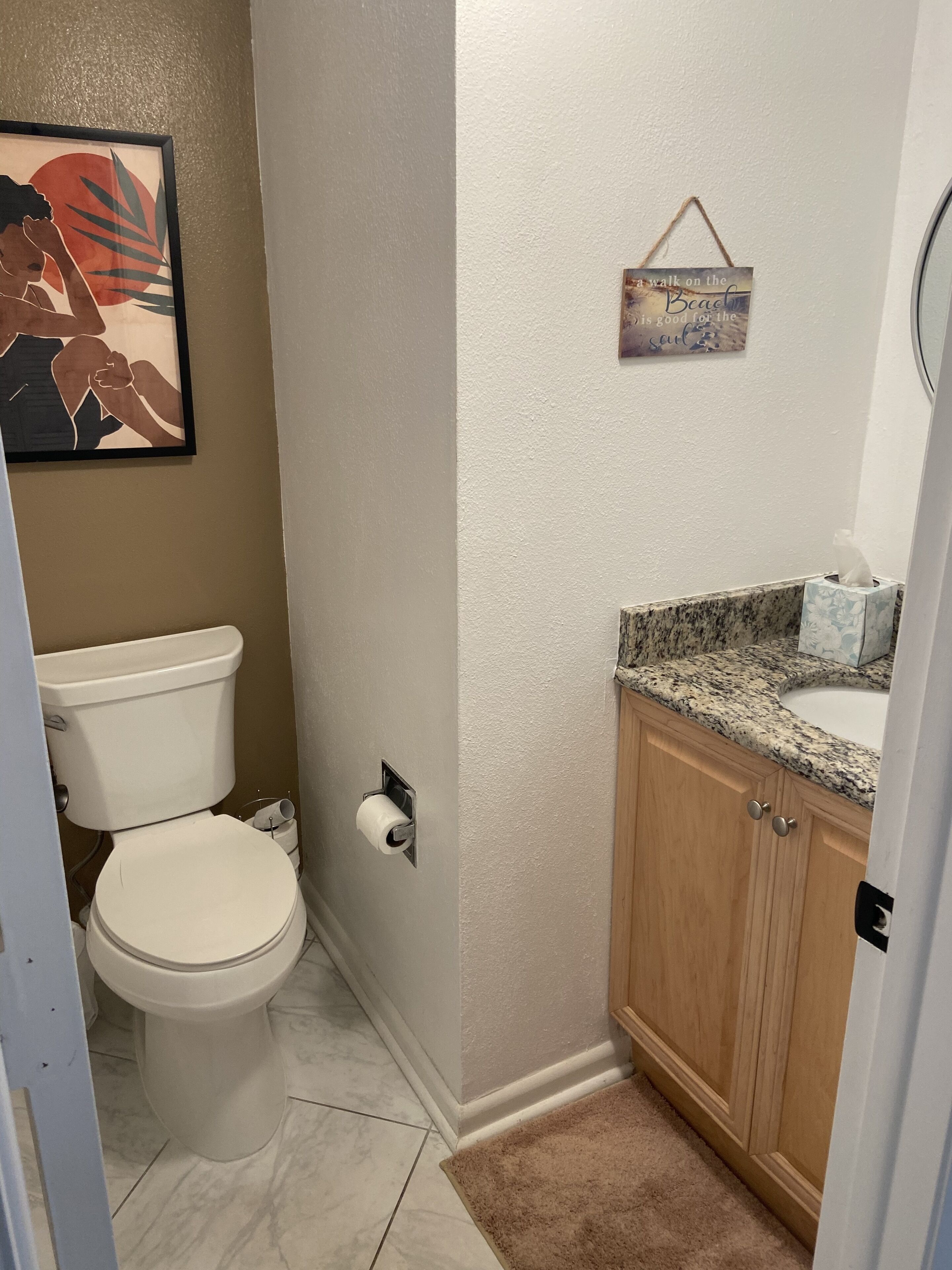 A small bathroom with a toilet, a sink, and a cabinet.