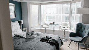 A modern hotel room with a large bed, a laptop, a coffee table, and two chairs. - casa para viajeros de poco presupuesto (Quetzaltennago)