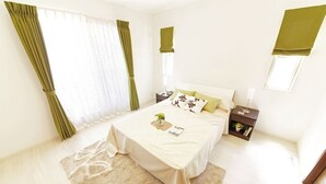 A bedroom with a bed, a nightstand, a bedside table, a window with curtains, and a small shelf. - casa para viajeros de poco presupuesto (Quetzaltennago)