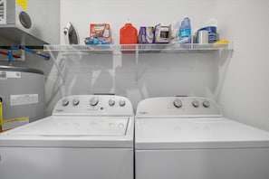 Convenient laundry facilities with two washing machines and storage for essentials.