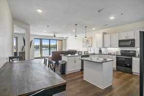 Enjoy meals in the kitchen with a central island, dining area, and large windows offering a view of the water.