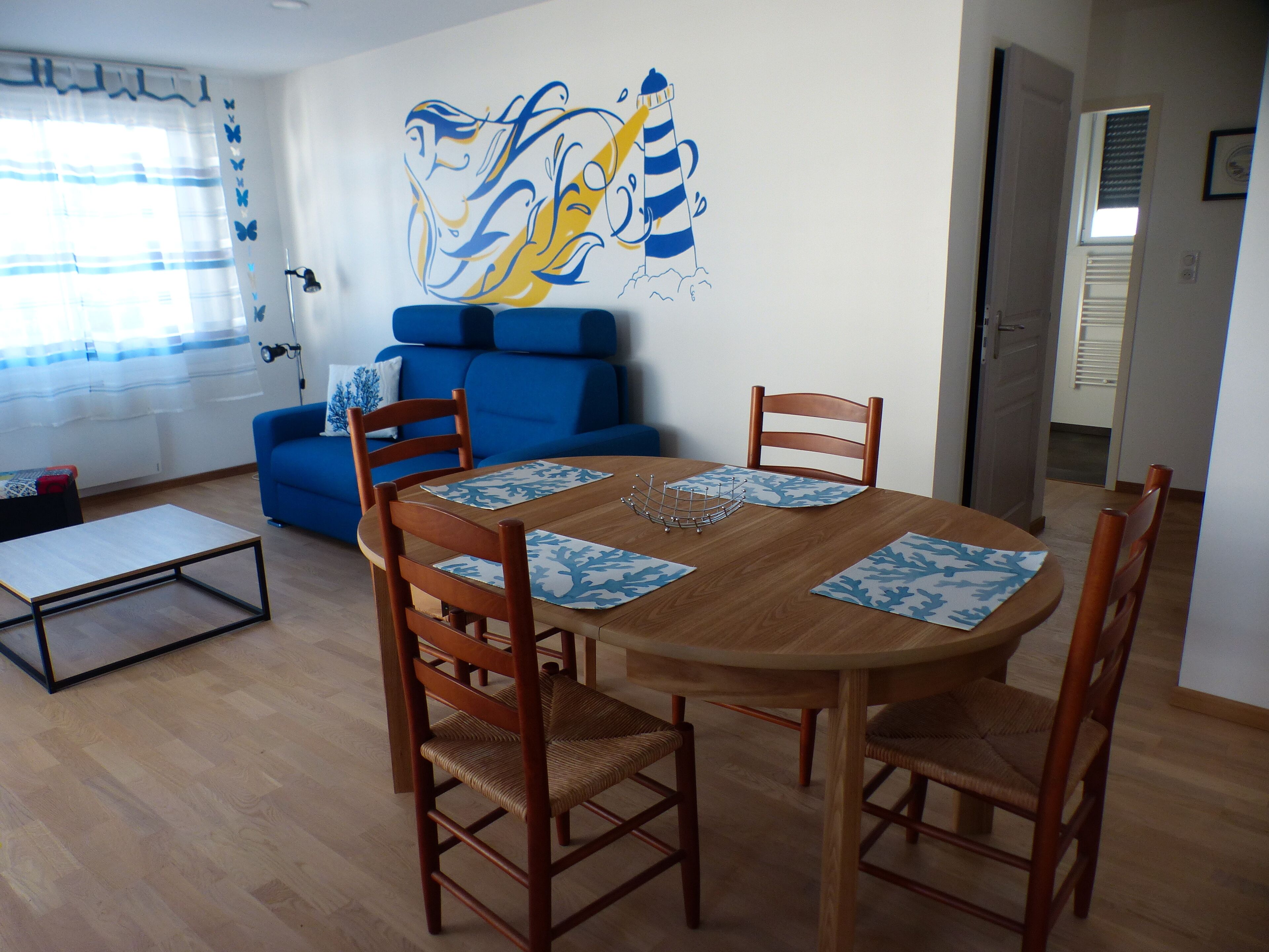 Een eethoek met een houten tafel, vier stoelen en een placemat met een blauw-wit patroon.