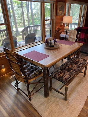 A wooden dining table with benches, a lamp, and a decorative plate with salt and pepper shakers.