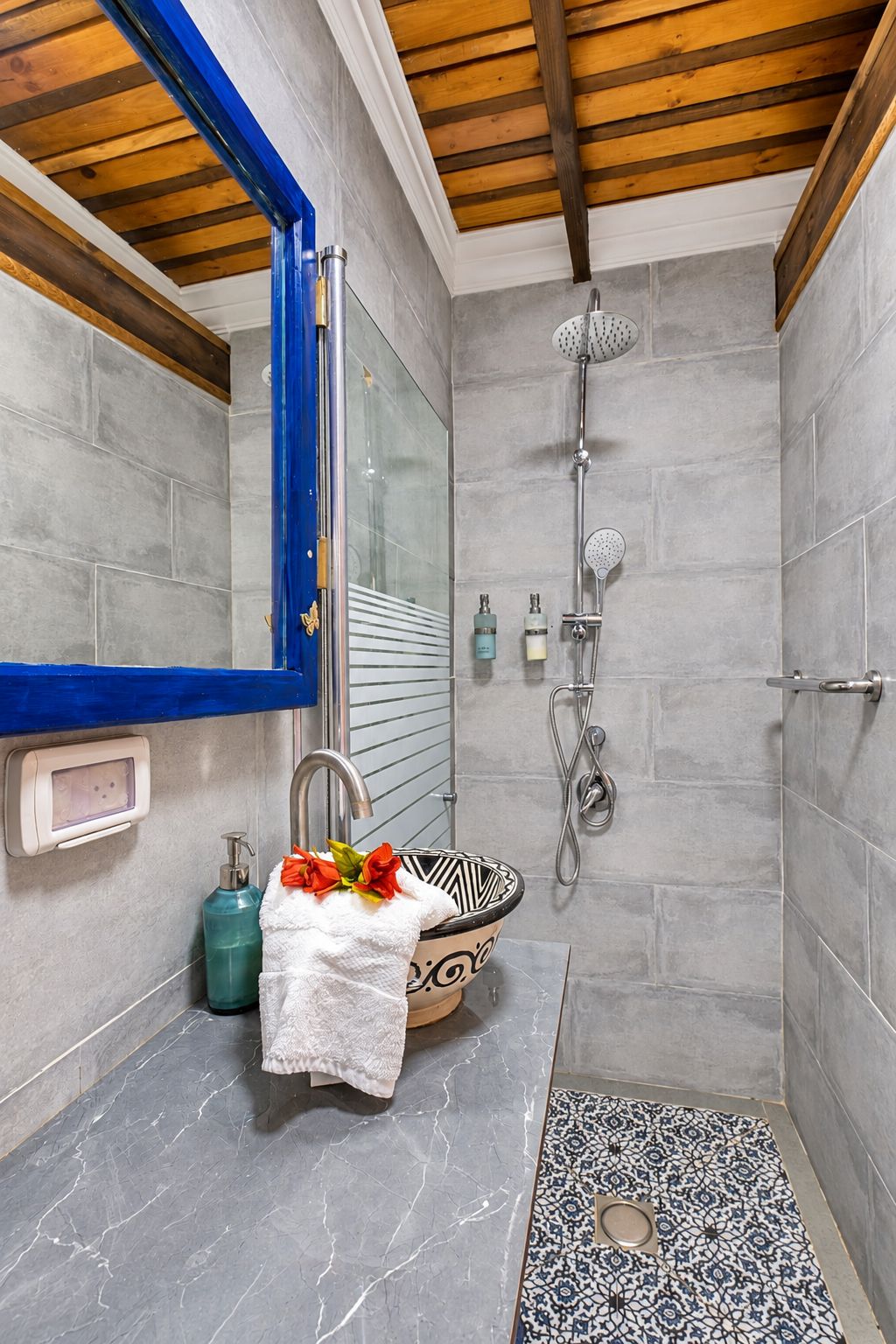 Un baño con ducha, un lavabo de diseño y jabonera.