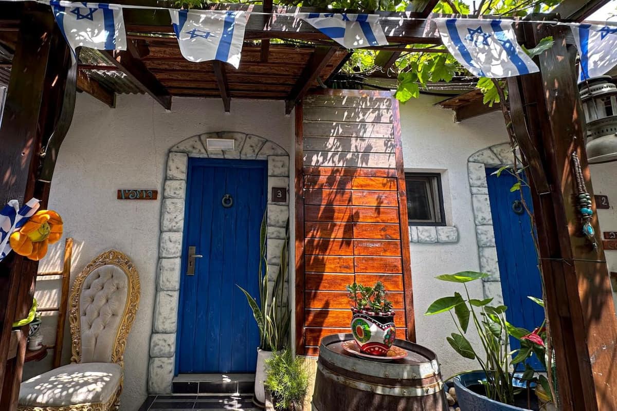 A building with a blue door, a stone wall, and a wooden bench.