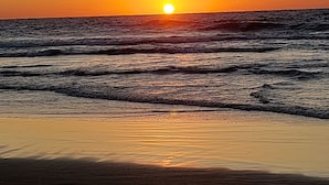 A sunset over the ocean with waves approaching the shore. - Ahuzat Shaul Hotel Seaside (Hadera)