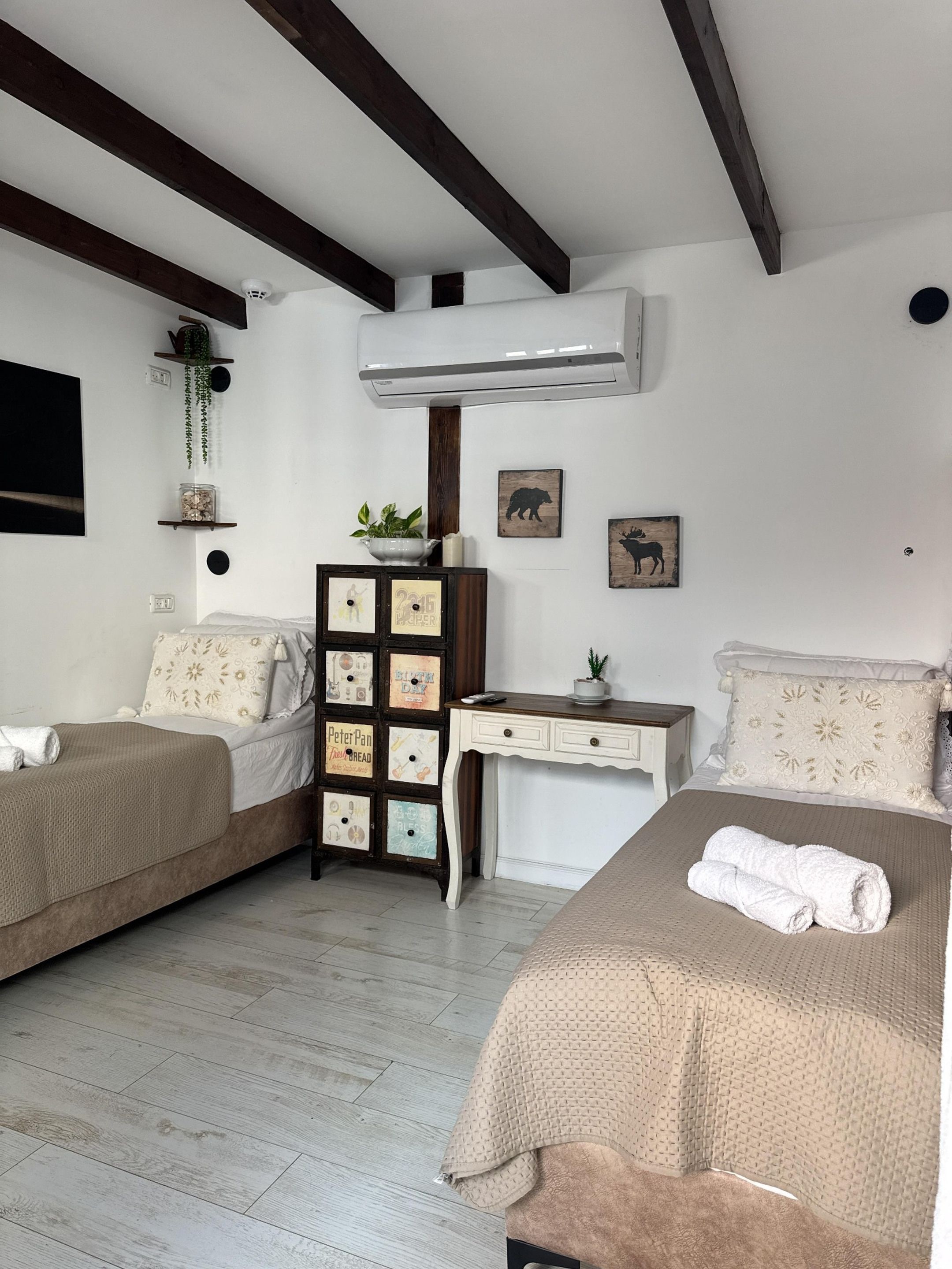 Une chambre avec deux lits, une commode et un bureau.