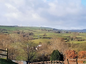A rural landscape with wind turbines, rolling hills, and a fenced area with trees. - 2 bedroom accommodation in Prion, near Denbigh (Prion, near Denbigh)