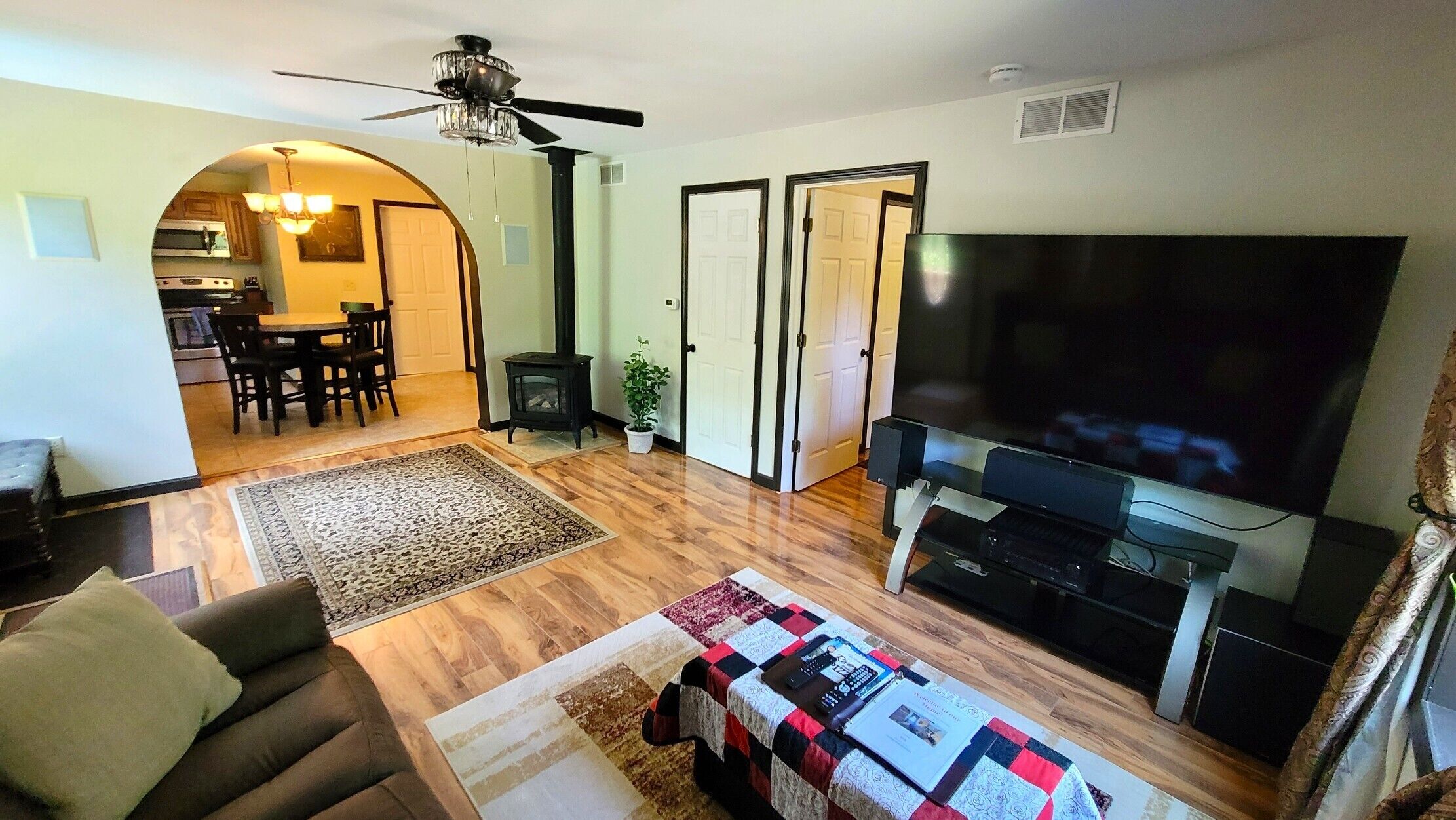 A living room with a sofa, a TV, a fireplace, and a dining area with a table and chairs.