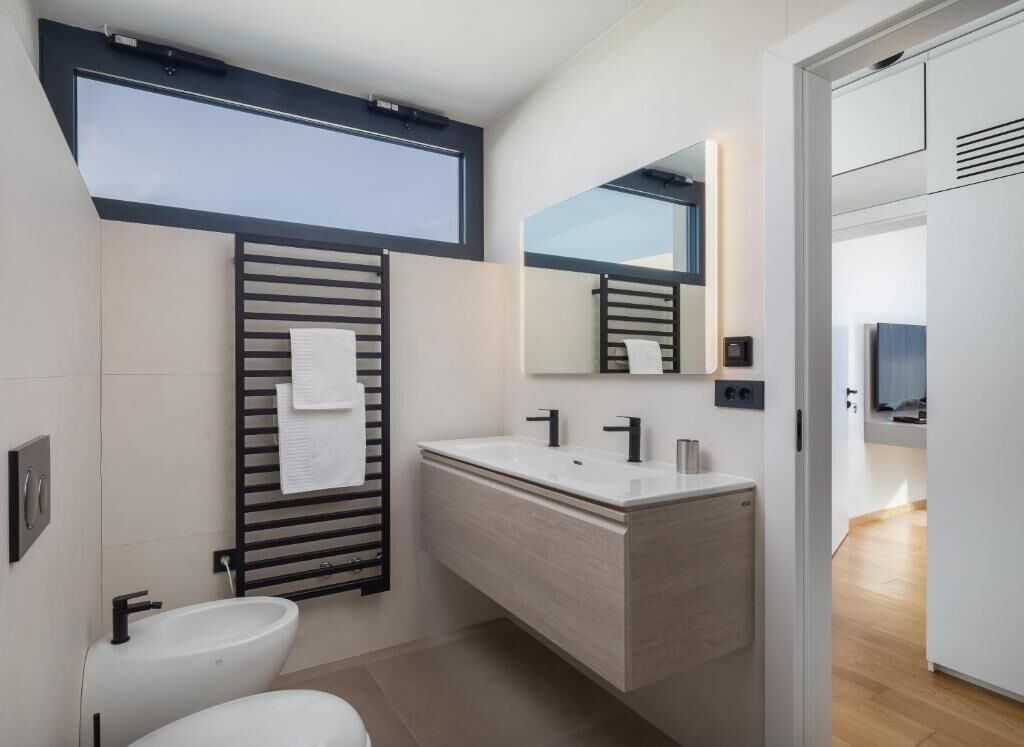 A modern bathroom with a toilet, bidet, and a vanity with a mirror.