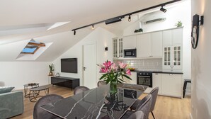 Eine moderne Küche mit weißen Schränken, einer schwarzen Mikrowelle und einem eingebauten Backofen.