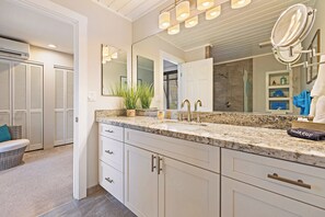 Un bagno con uno specchio grande, un lavandino con rubinetto e un portasciugamani.