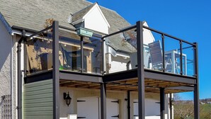 A two-story house with a balcony, a white door, and a black railing. - Grange Loft - UK31594 (Dundee)