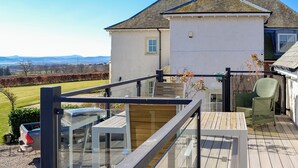 A deck with a railing, a table, and a chair. - Grange Loft - UK31594 (Dundee)