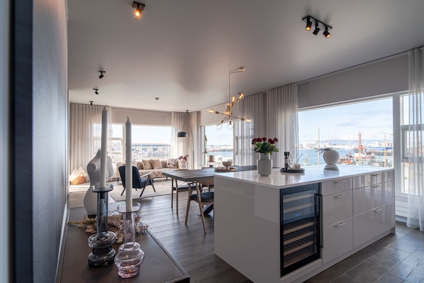 Enjoy meals and relaxation in this kitchen and dining area with a central island, oven, and city views.