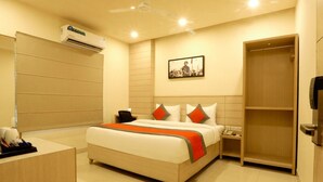 A hotel room with a bed, bedside table, nightstand, and a wardrobe. - Sagar Residency (Amritsar)