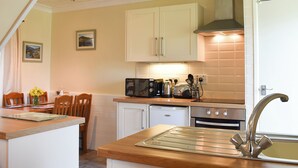 A kitchen with white cabinets, a microwave, a toaster, and a sink.