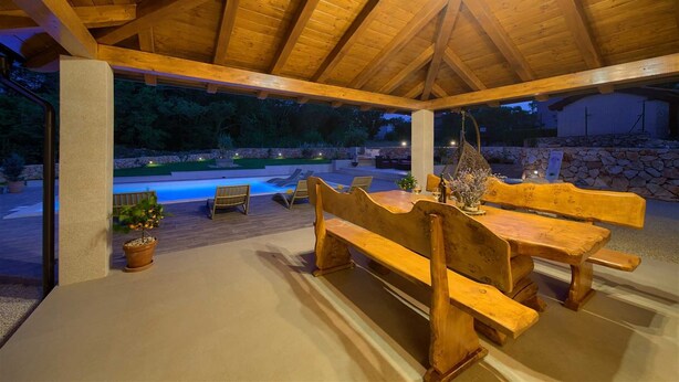 An outdoor wooden pavilion with a pool, lounge chairs, and a dining table. - Beautiful Villa Green Pearl with heated pool (Gostinjac (Krk))