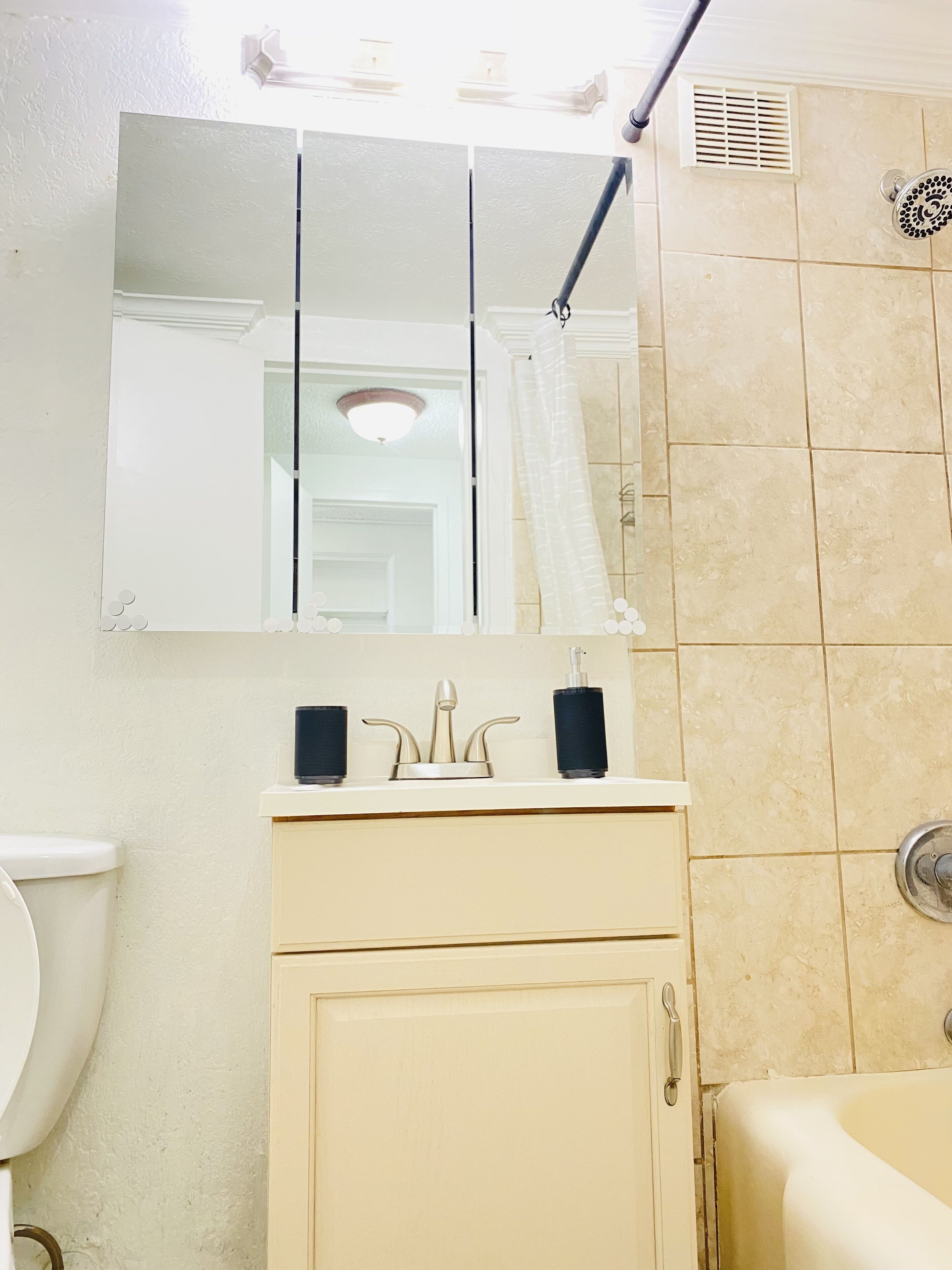Ein Badezimmer mit Toilette, Waschbecken, Spiegel, Dusche und Badewanne.