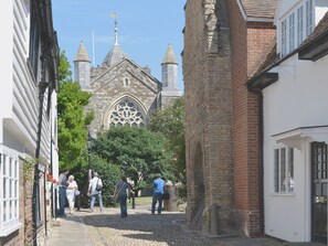 A narrow street with historic buildings, including a church with a large stained glass window and multiple spires. - 1 bedroom accommodation in Northiam, near Rye (Northiam, near Rye)