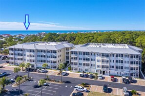 A multi-story hotel with a parking lot and a view of the ocean. - 2 Blocks 2 Beach, Walk to Seaside, Pool, Beach Gear, New Kitchen (Santa Rosa Beach)