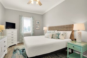 A bedroom with a bed, bedside tables, a dresser, a television, and a window with curtains. - 2 Blocks 2 Beach, Walk to Seaside, Pool, Beach Gear, New Kitchen (Santa Rosa Beach)